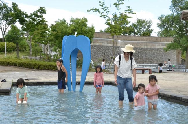 水遊びを楽しむ家族連れや子どもたち